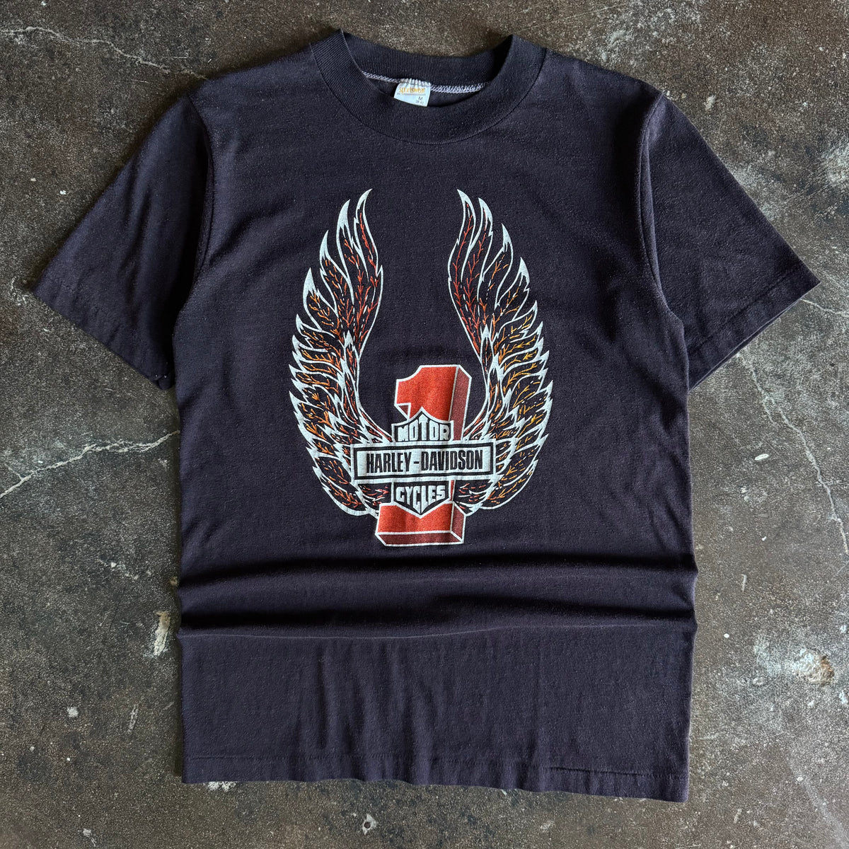 Black short-sleeve t-shirt with centered Harley-Davidson winged emblem graphic and Texas text