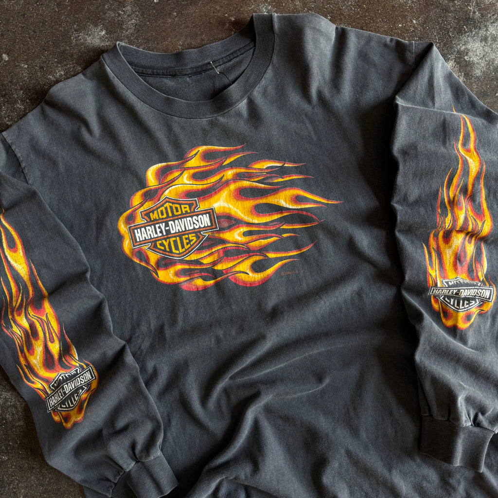 Detail of rushing flames bar and shield graphic on vintage sun faded Harley longsleeve